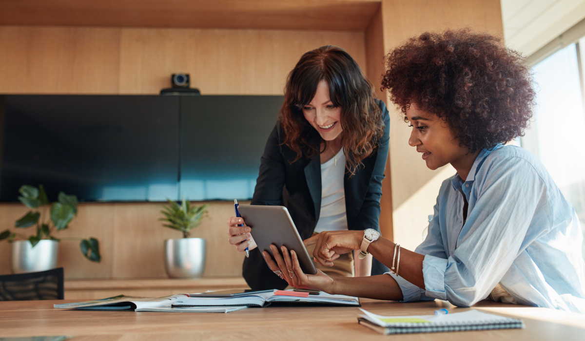 Two women looking at a laptop in a professional setting